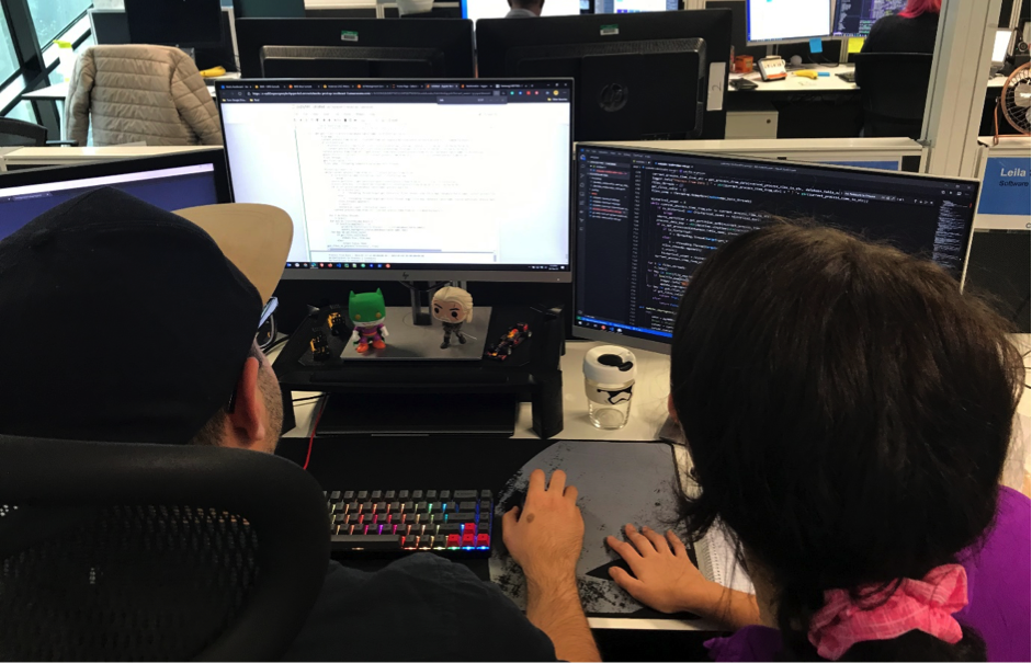 Two young professionals discussing over something facing a computer screen