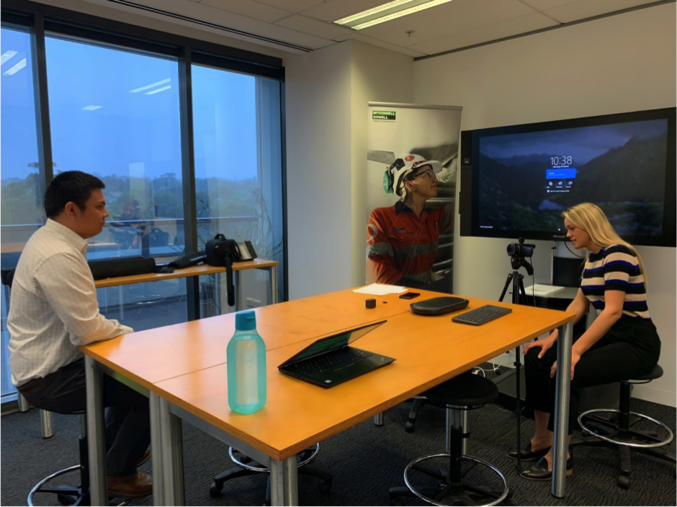 Three young professionals setting up a meeting room.