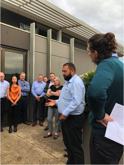 McConnell Dowell Su Group of colleagues conducting the smoking ceremony outside a building