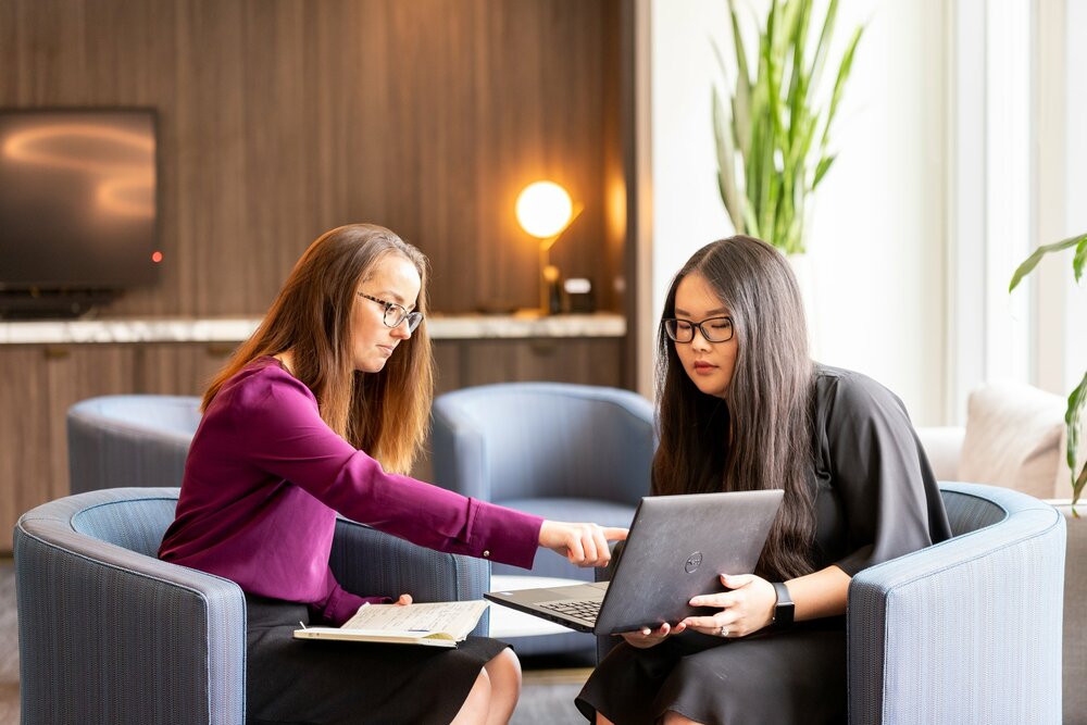 Two young professionals discussing something on a laptop