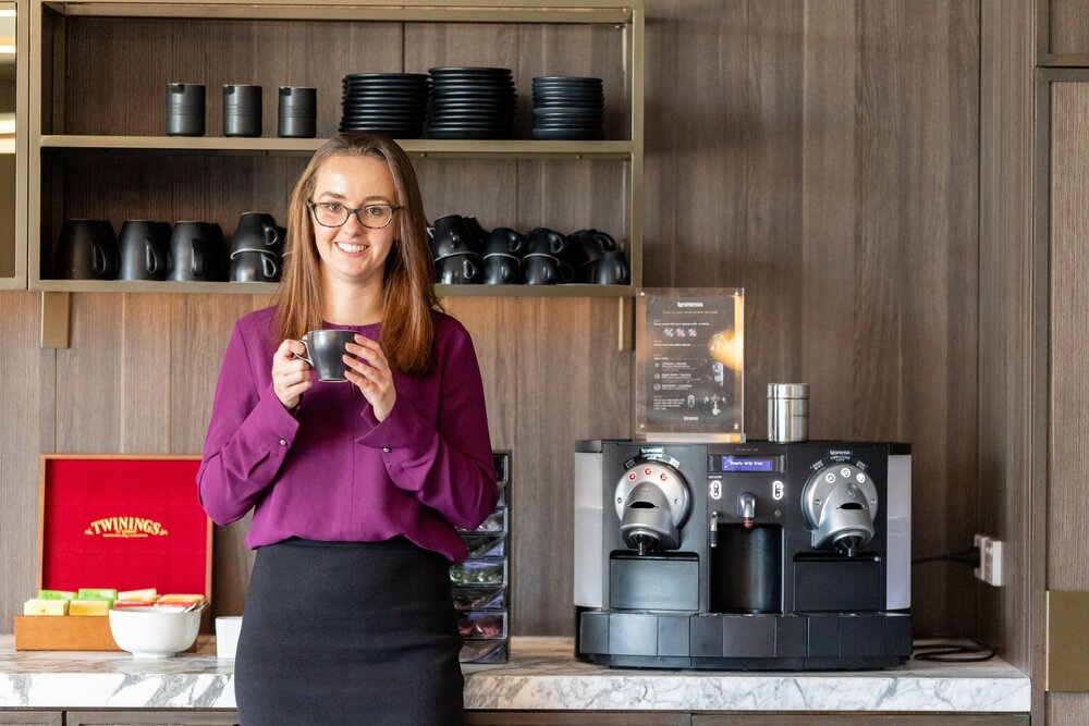 A young professional holding a cup of coffee