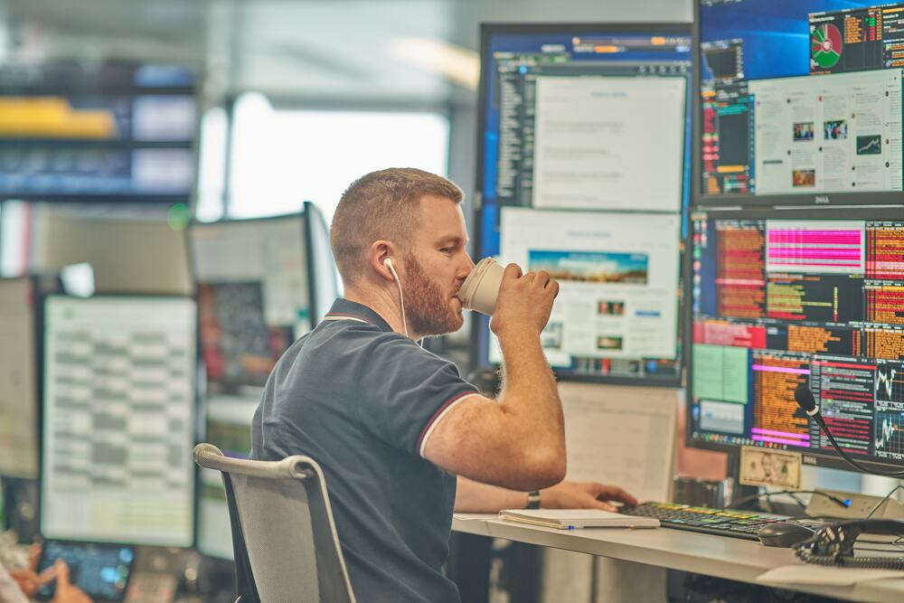 A young professional having coffee at his desk