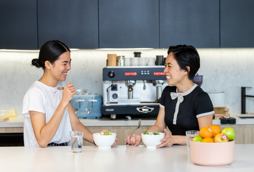 Exponential Trading Graduate- Two women eating their lunch happily.
