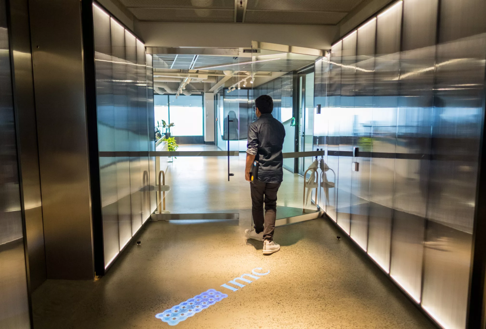IMC Graduate- Male professional walking through the door to his office.