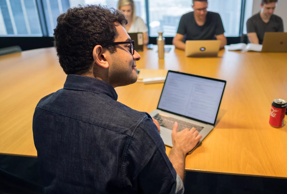 IMC Graduate- A software engineer coding on his laptop computer.